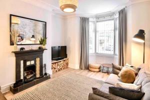a living room with a couch and a fireplace at Sea Retreats, Whitley Bay, Sleeps 8 in Whitley Bay