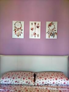 a bed with four pictures on a purple wall at Suite Paradiso in Castelnuovo Magra