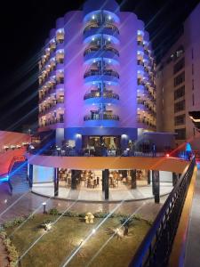 فندق اللوتس  في الأقصر: مبنى به أضواء أرجوانية في الليل