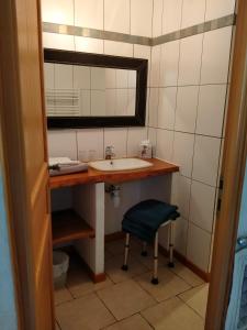 a bathroom with a sink and a mirror and a stool at Au coeur du Caylar in Le Caylar