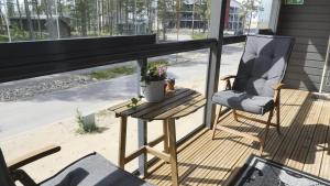 a chair and a table on a porch with a window at Tahkokorva Apartments by Hiekka Booking in Kalajoki