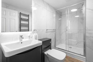 a white bathroom with a sink and a shower at Still House in Boston