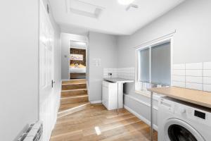 a white laundry room with a washer and dryer at Still House in Boston
