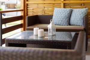 イプソスにあるPlanet Villas by Konnect - Shared BBQ & Gardenの籐椅子にキャンドル2本付テーブル