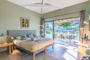 a bedroom with a bed and a patio with a table at Easy Clés-Luxury Villa 16p breathtaking view in Guéthary