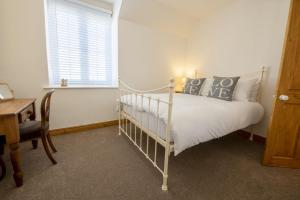 Un pat sau paturi într-o cameră la Gilly Cottage