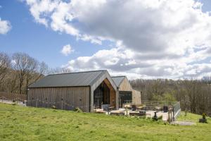 a barn in a field with a cloudy sky at Gilly Cottage in South Cave