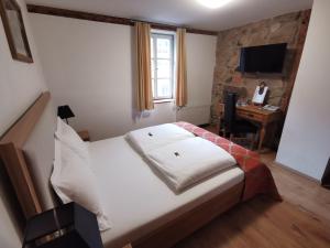 1 dormitorio con 1 cama y escritorio con ordenador en Hotel Hahnmühle 1323 en Coburg