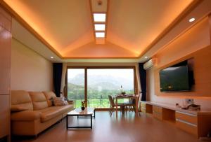 a living room with a couch and a large window at Ulsanbawi Rock View Apartment in Sokcho