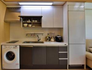 a kitchen with a sink and a washing machine at Ulsanbawi Rock View Apartment in Sokcho