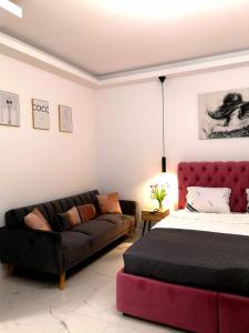 ein Wohnzimmer mit einem Bett und einer Couch in der Unterkunft Promenada Beach Residence in Mamaia Nord – Năvodari