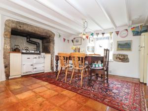 a kitchen with a table and chairs in a room at Rose Cottage in Penzance