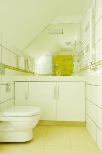 ein weißes Bad mit einem WC und einem Waschbecken in der Unterkunft Vinosseum Bor- és Apartmanház in Sopron
