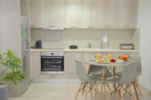 une cuisine avec une table, des chaises et des oranges. dans l'établissement Alkyonis Apartment Milos, à Triovasálos