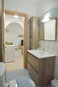 a bathroom with a sink and a toilet at Alkyonis Apartment Milos in Triovasálos