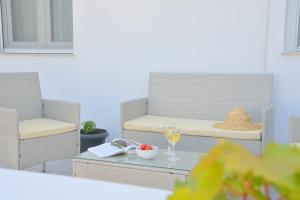 une terrasse avec une chaise et un verre de vin dans l'établissement Alkyonis Apartment Milos, à Triovasálos