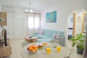 a living room with a table and a blue couch at Alkyonis Apartment Milos in Triovasálos