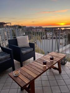 eine Terrasse mit einem Tisch und Stühlen sowie einem Sonnenuntergang in der Unterkunft Pizzo Heights in Pizzo