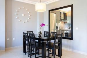 a dining room with a black table and chairs and a mirror at La Casita Gris in Sauzal