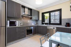 a kitchen with brown cabinets and a glass table at La Casita Gris in Sauzal