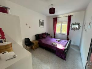 ein kleines Schlafzimmer mit einem lila Bett und einem Fenster in der Unterkunft Pizzo Heights in Pizzo
