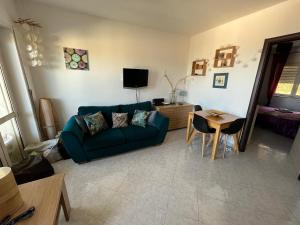 ein Wohnzimmer mit einem grünen Sofa und einem Tisch in der Unterkunft Pizzo Heights in Pizzo