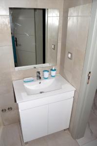 a bathroom with a white sink and a mirror at AG TOUR LDA - Apartamentos Turísticos in Praia +26 photos