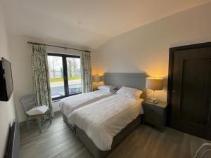 A bed or beds in a room at Tullybay Holiday Lodges