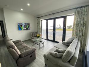 a living room with two couches and a tv at Tullybay Holiday Lodges in Enniskillen