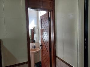 a bathroom with a toilet and a sink and a door at Pousada Hotel Santa Helena in Juazeiro do Norte