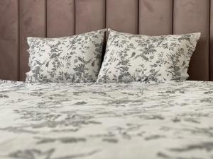 a bed with two pillows and a white comforter at Best Apartment City Hall in Suceava