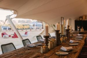 a long table in a tent with candles on it at Caravan by Habitas AlUla in Al Ula