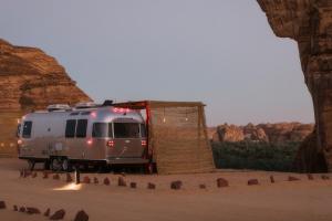 a silver camper parked next to a tent in the desert at Caravan by Habitas AlUla in Al Ula