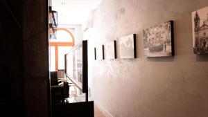 a hallway with a bunch of pictures on a wall at Quaint Boutique Hotel Sannat in Sannat