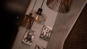 a chandelier hanging from a wall with pictures at Quaint Boutique Hotel Sannat in Sannat