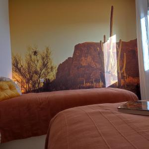 a bedroom with a bed with a mountain mural on the wall at Maison la grande serre in Blaslay