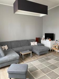 a living room with a gray couch and a table at Régimódi Apartman in Siófok