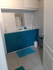 y baño con lavabo azul y espejo. en Gîte de Kerezenn, en Fougerolles