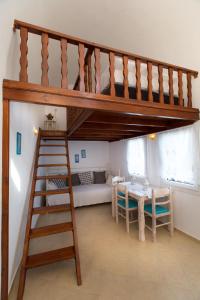 a living room with a loft bed and a table at Aelia Suites in Akrotiri