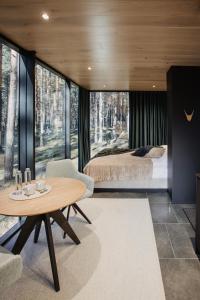 ein Schlafzimmer mit einem Bett und einem Tisch in einem Zimmer in der Unterkunft ÖÖD Hötels Laheranna SÄRA -with sauna in Punakivi