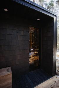 ÖÖD Hötels Laheranna SÄRA -with sauna في Punakivi: باب زجاجي منزلق على جانب المنزل
