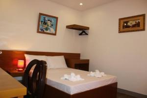 una camera da letto con un letto con due asciugamani bianchi di Casa Belina a Città di Puerto Princesa