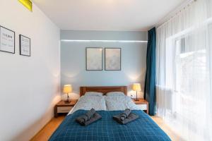 a bedroom with a blue bed with two pillows on it at Mieszkania I studio I pokoje z łazienkami in Gdańsk