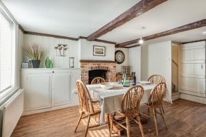 a dining room with a table and chairs and a fireplace at Smugglers Cottage in Christchurch