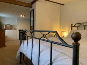 a bedroom with a bed with a metal frame at Smugglers Cottage in Christchurch