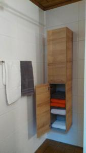 ein Holzschrank mit Handtüchern im Bad in der Unterkunft Haus Flora am Kaiser in Niederndorf