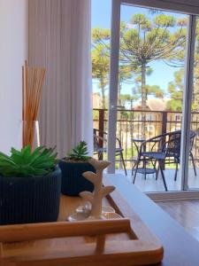 - un salon avec vue sur un balcon dans l'établissement Excelente apartamento em Gramado/RS no Condomínio Casa de Pedra, à Gramado