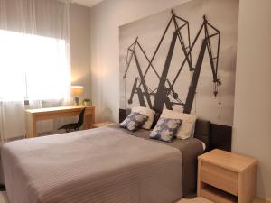 a bedroom with a bed with a painting on the wall at K2012 Kalina Grand-Tourist Apartments in Gdańsk