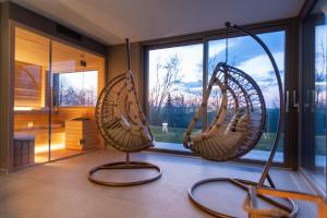 Verduno的住宿－Agriturismo Speziale Wine Resort，带大窗户的客房内的2把秋千椅