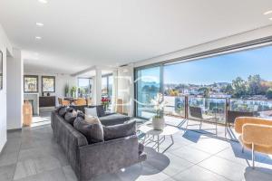 a living room with couches and a large window at Easy Clés - Villa Jacuzzi Pool AC in Saint-Jean-de-Luz